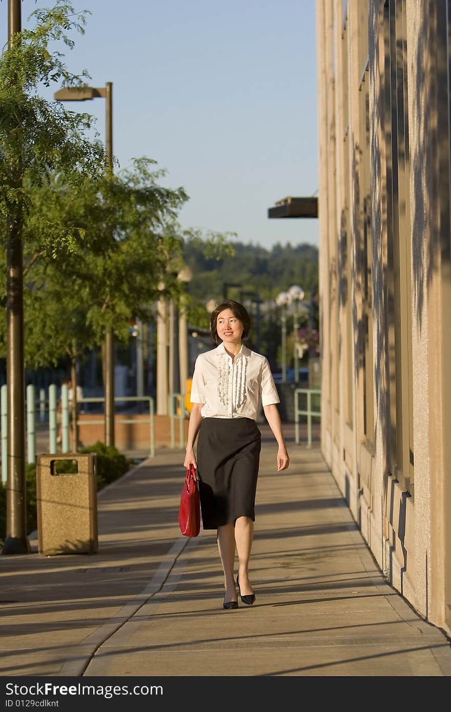 Smiling Woman Walks with Red Handbag - Horizontal