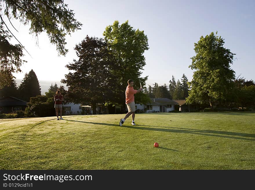 Couple Playing Golf On Course - Horizontal