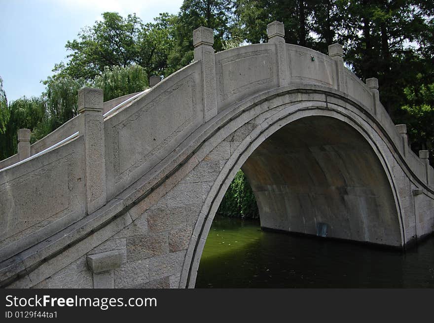 Arch bridge made of rock over a lake