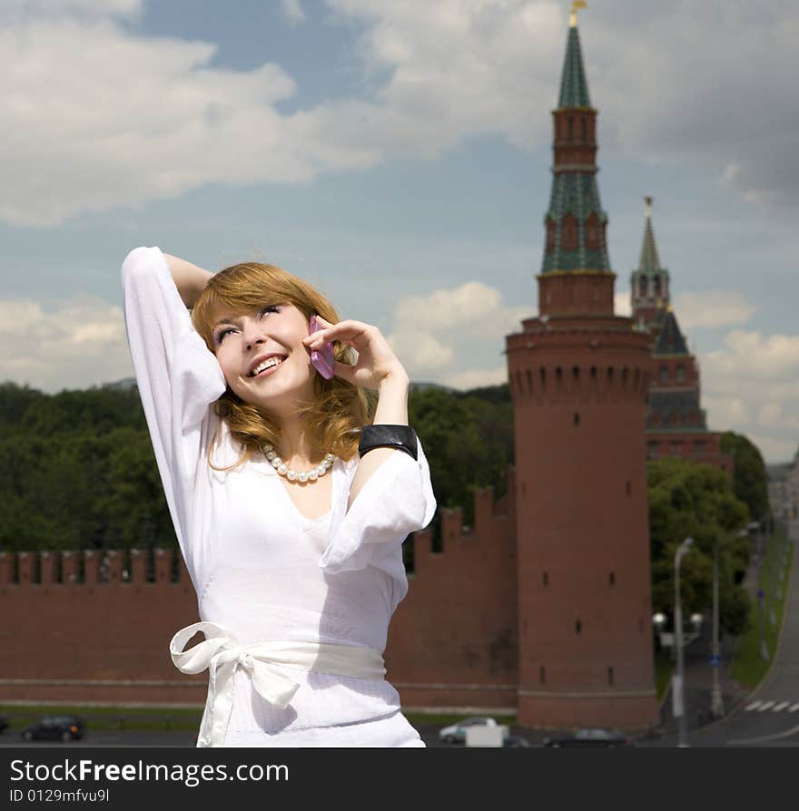 A photo of beautiful woman talking on the phone in Moscow near the Kremlin. A photo of beautiful woman talking on the phone in Moscow near the Kremlin