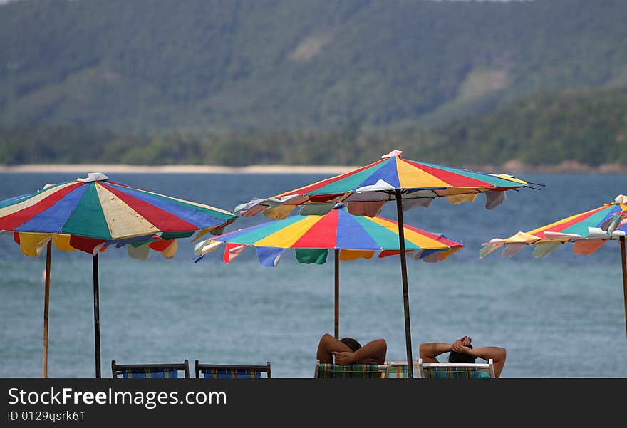 Colorfully sun beds and umbrellas in an island. Colorfully sun beds and umbrellas in an island