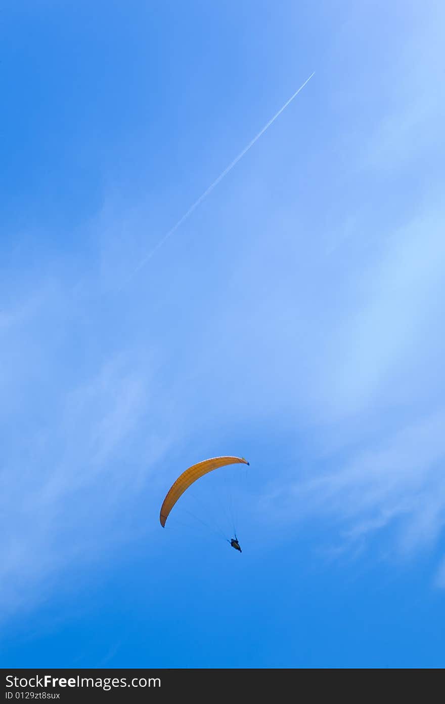 Man parachuting in blue sky. Man parachuting in blue sky