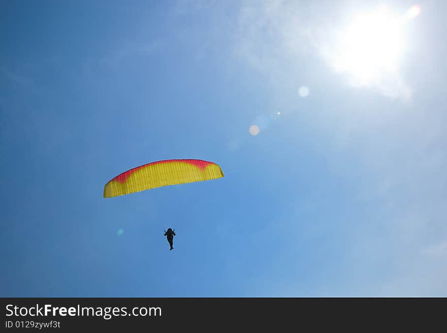 Man parasailing in blue sky. Man parasailing in blue sky