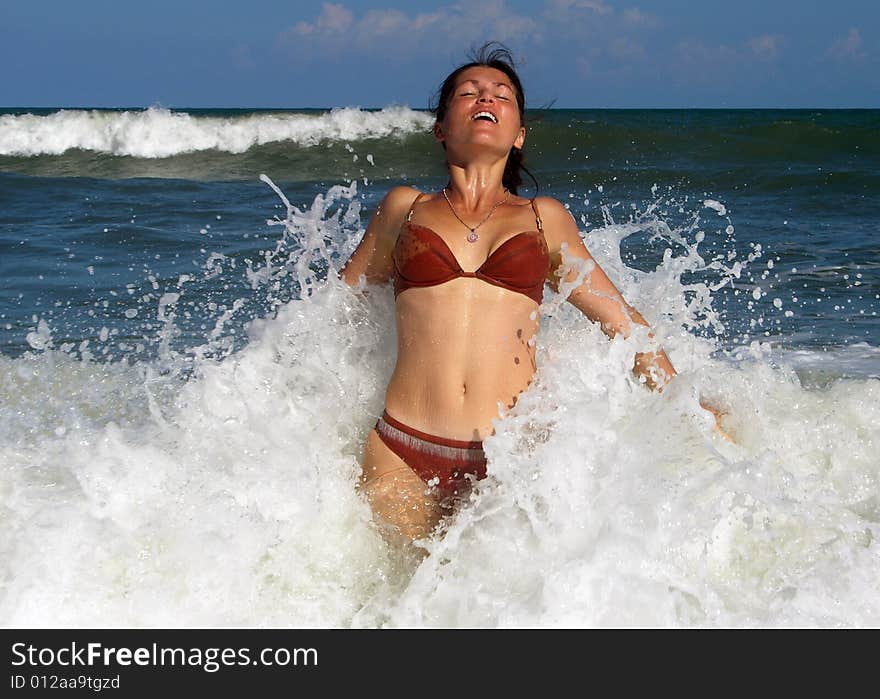 The girl playing with strong waves on Cape Canaveral town beach (Florida). The girl playing with strong waves on Cape Canaveral town beach (Florida).