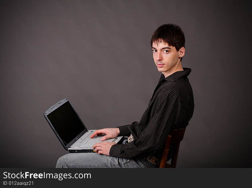 Casual young man sitting with laptop