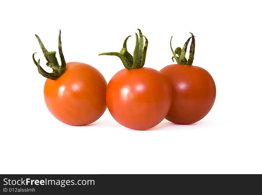 Three red cherry tomatoes isolated on white background. Three red cherry tomatoes isolated on white background