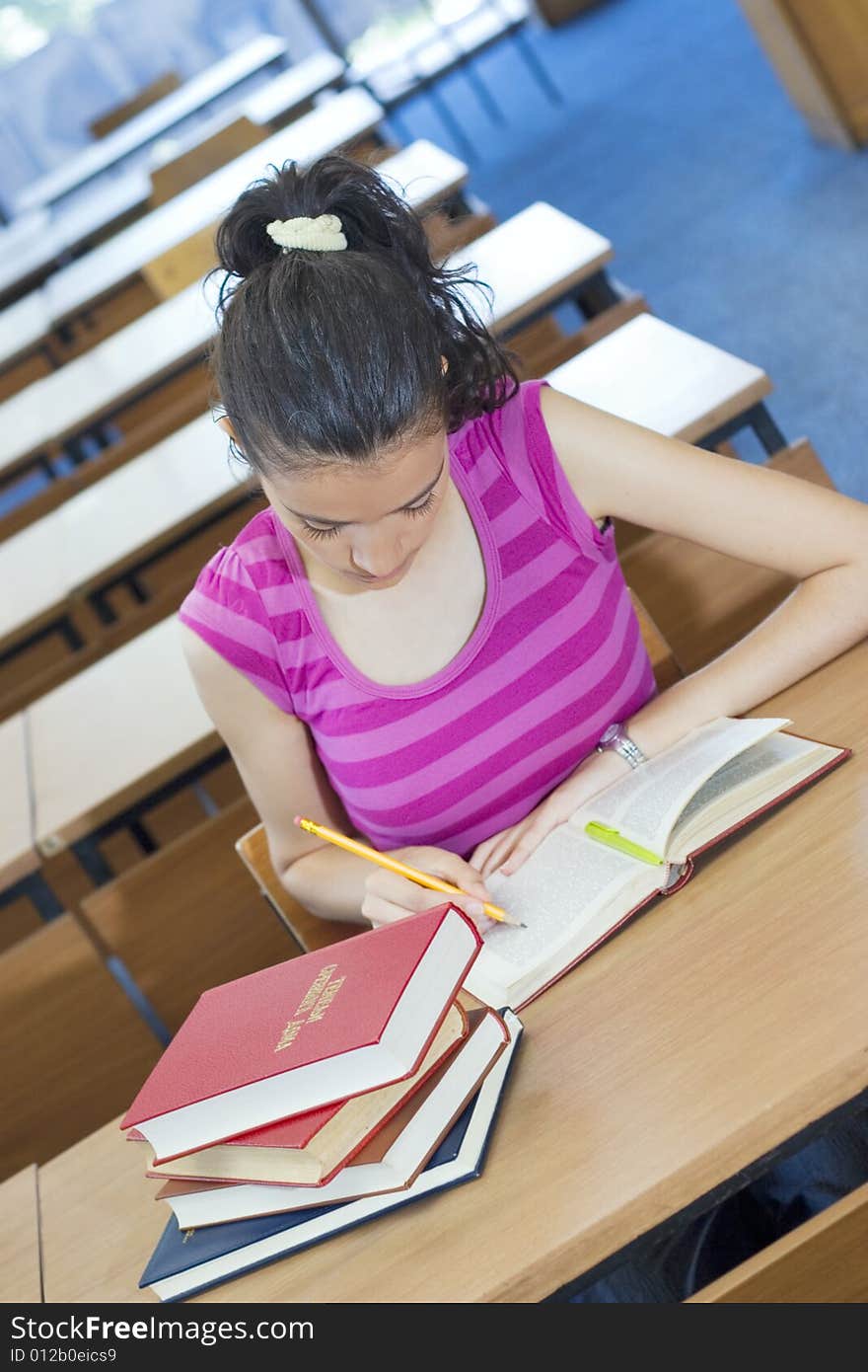 Young beautiful student in college studing in library