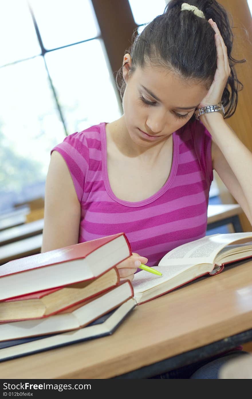 Young beautiful student in college studing in library