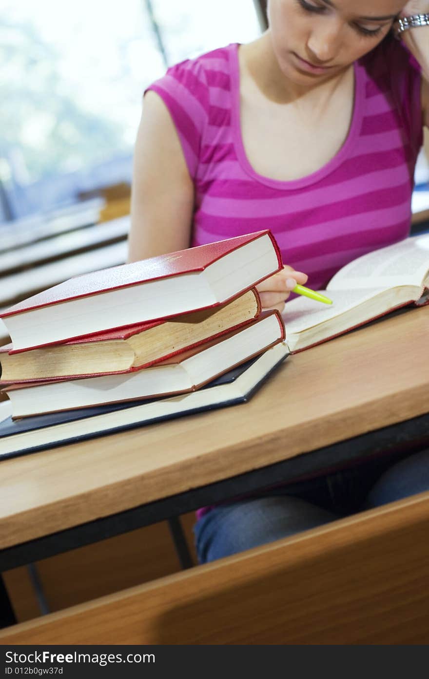 Young beautiful student in college studing in library