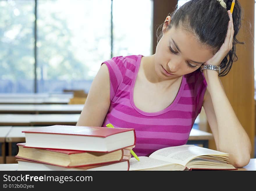 Young beautiful student in college studing in library