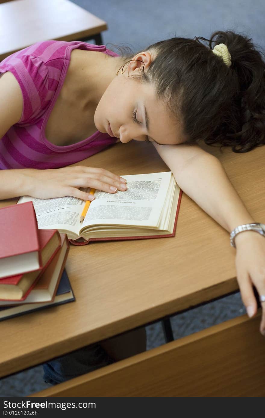 Young beautiful student in college sleeping in library