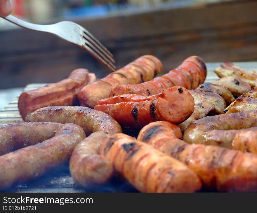 Close-up of grilled sausages on wire rack. Focus on center.