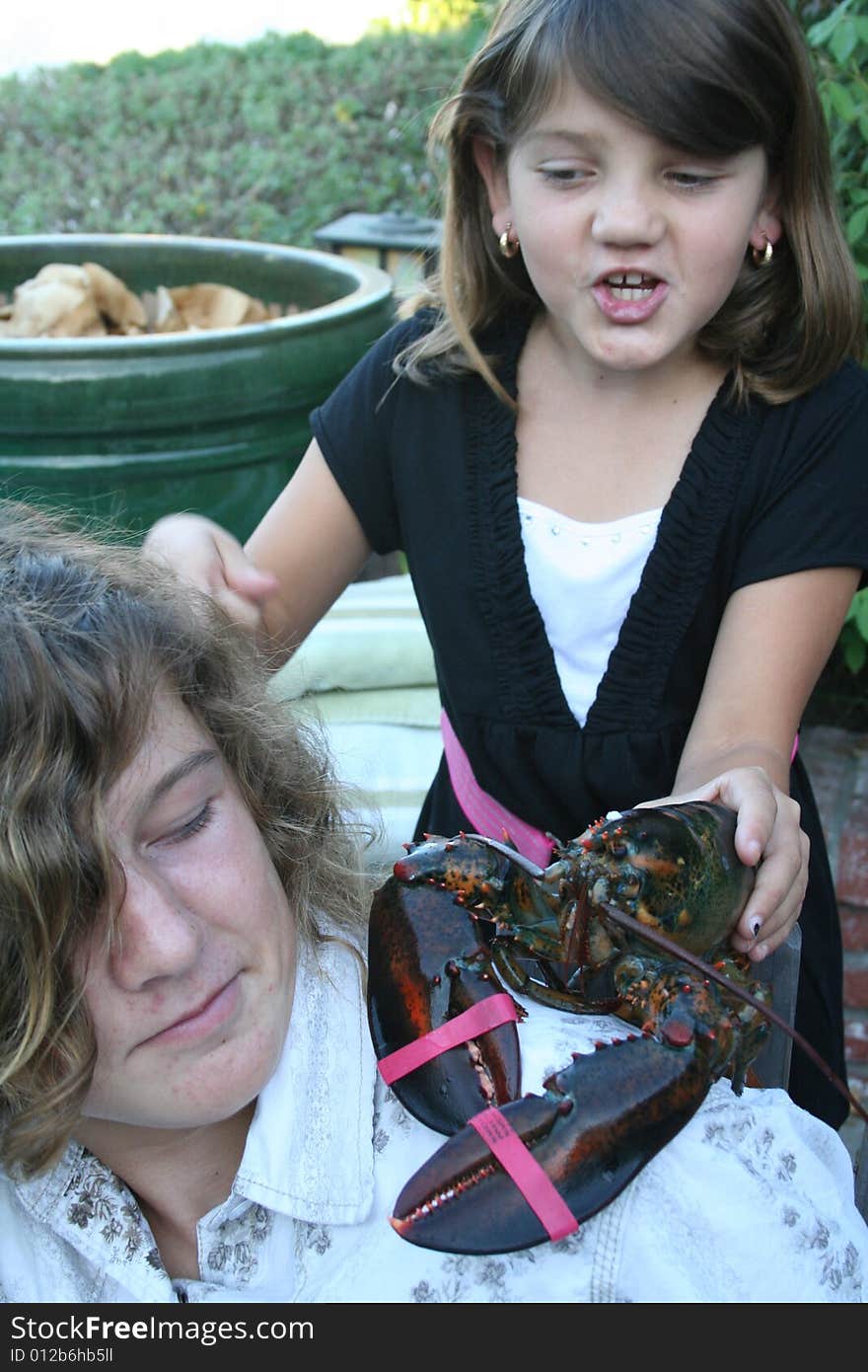 Girl holding a lobster over her brother's sholder. Girl holding a lobster over her brother's sholder.