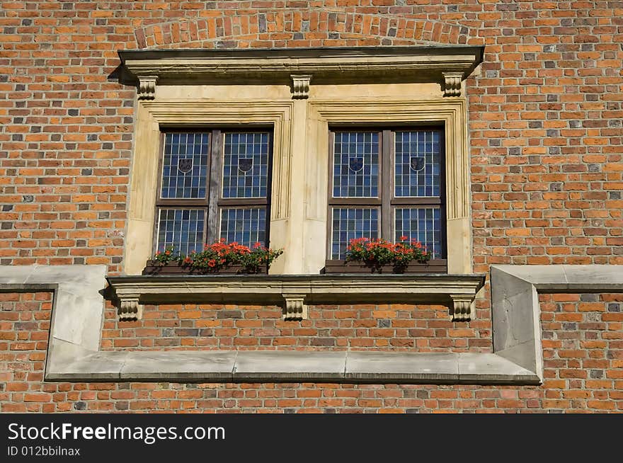 Double window over red brick wall