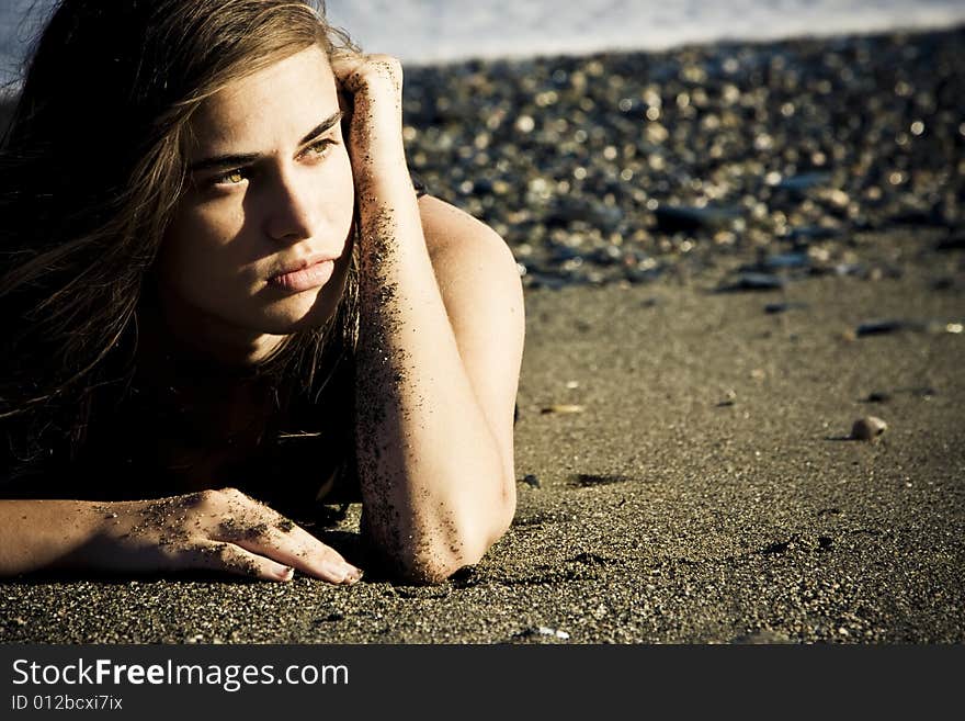 Green eyed beauty laying over the sand. Green eyed beauty laying over the sand