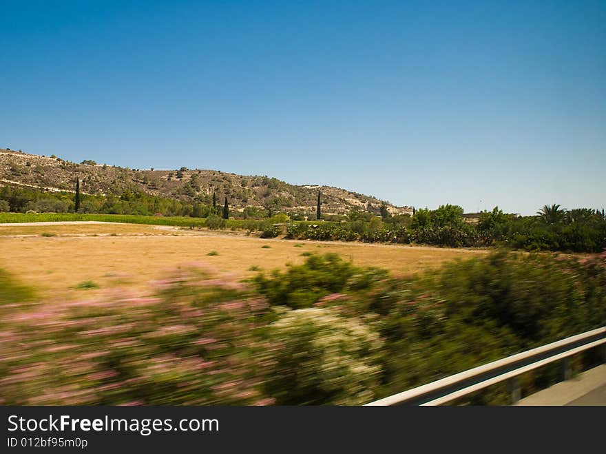 This view from road to dry landscape with hills far away