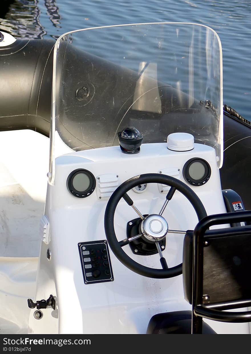 The motor boat wheel and control panel close up. The motor boat wheel and control panel close up.