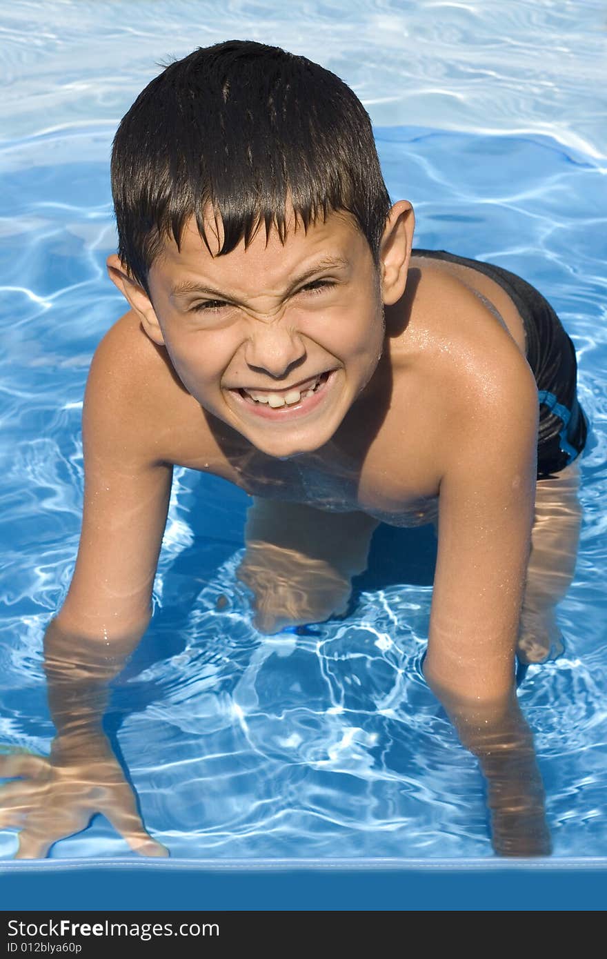 Cute young boy in pool smiling