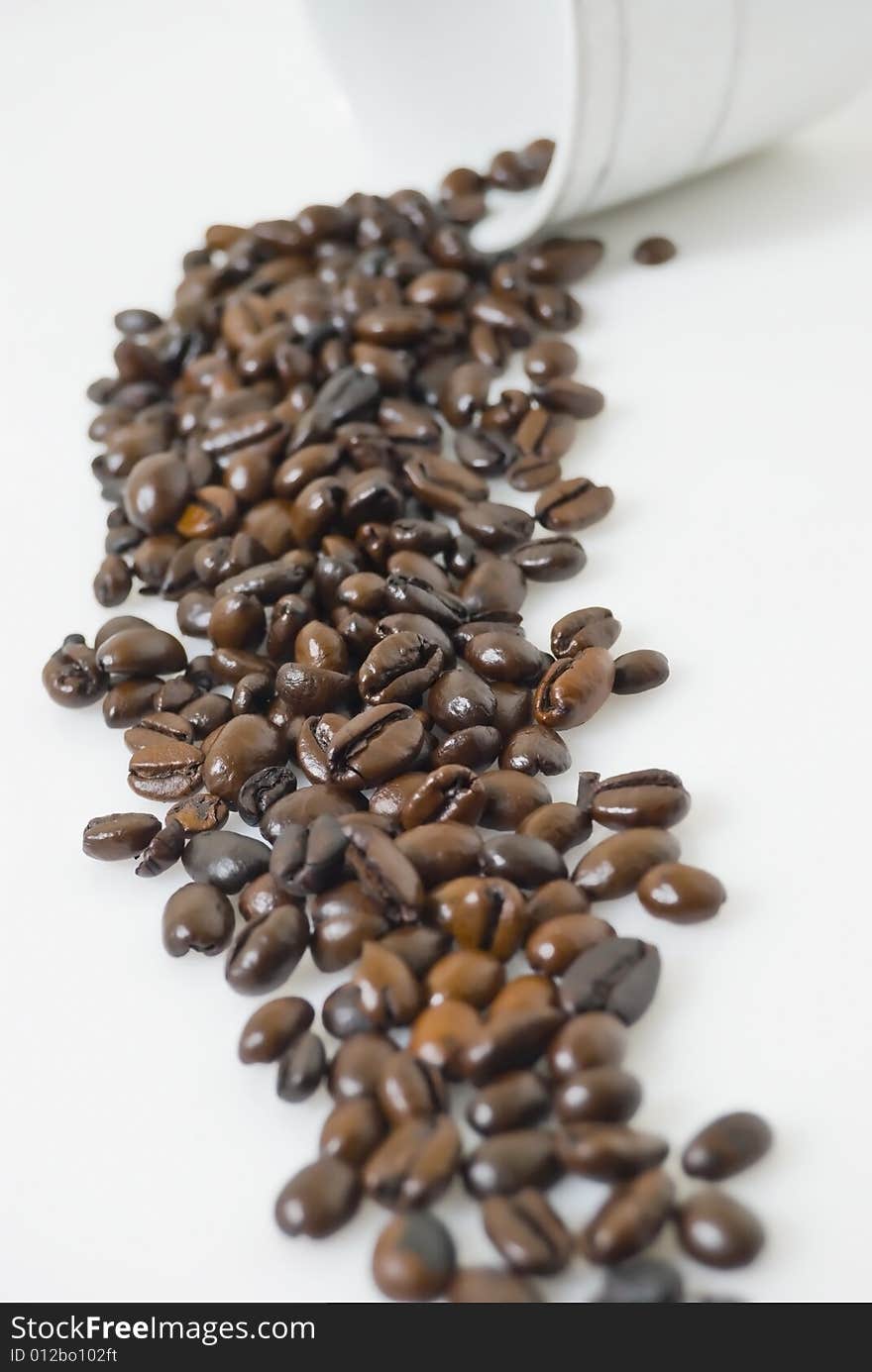 Closeup shot of coffee beans pouring out from cup,