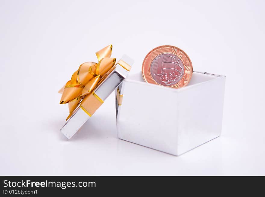 Box to gift and coin on the white background