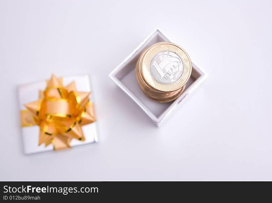 Box to gift and coin on the white background