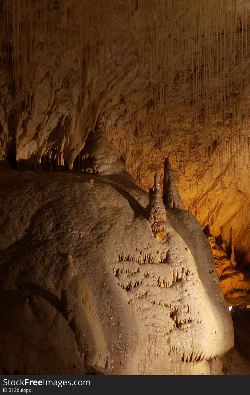 Tall unusual stalagmites and stalactites in the underground cavern in france, vertical