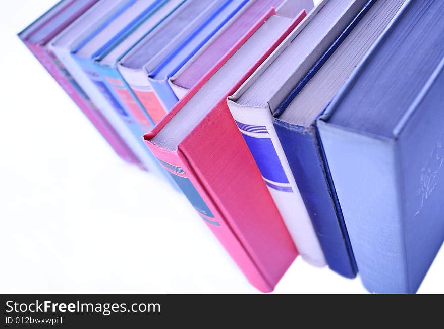 Row of books lined up in row with red book out in front