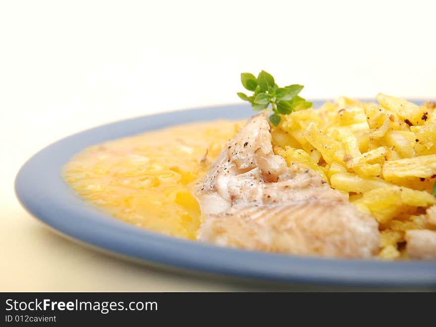 Alaska pollock on thin fries with delicious mango sauce arranged on a blue plate. Close-up. Alaska pollock on thin fries with delicious mango sauce arranged on a blue plate. Close-up.