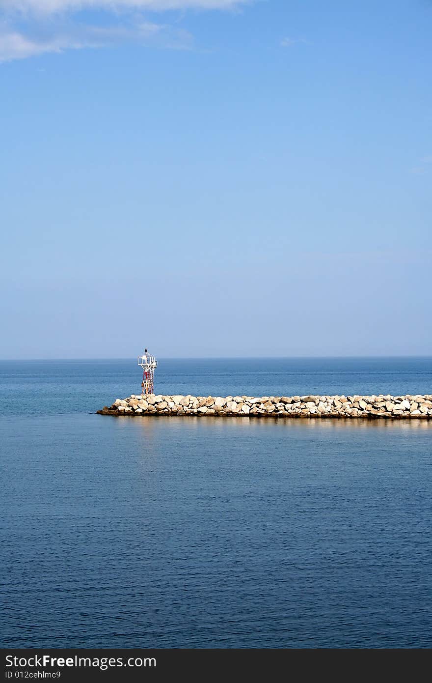 Boulder stones at the entrance to the port with watch-tower in the back. Boulder stones at the entrance to the port with watch-tower in the back