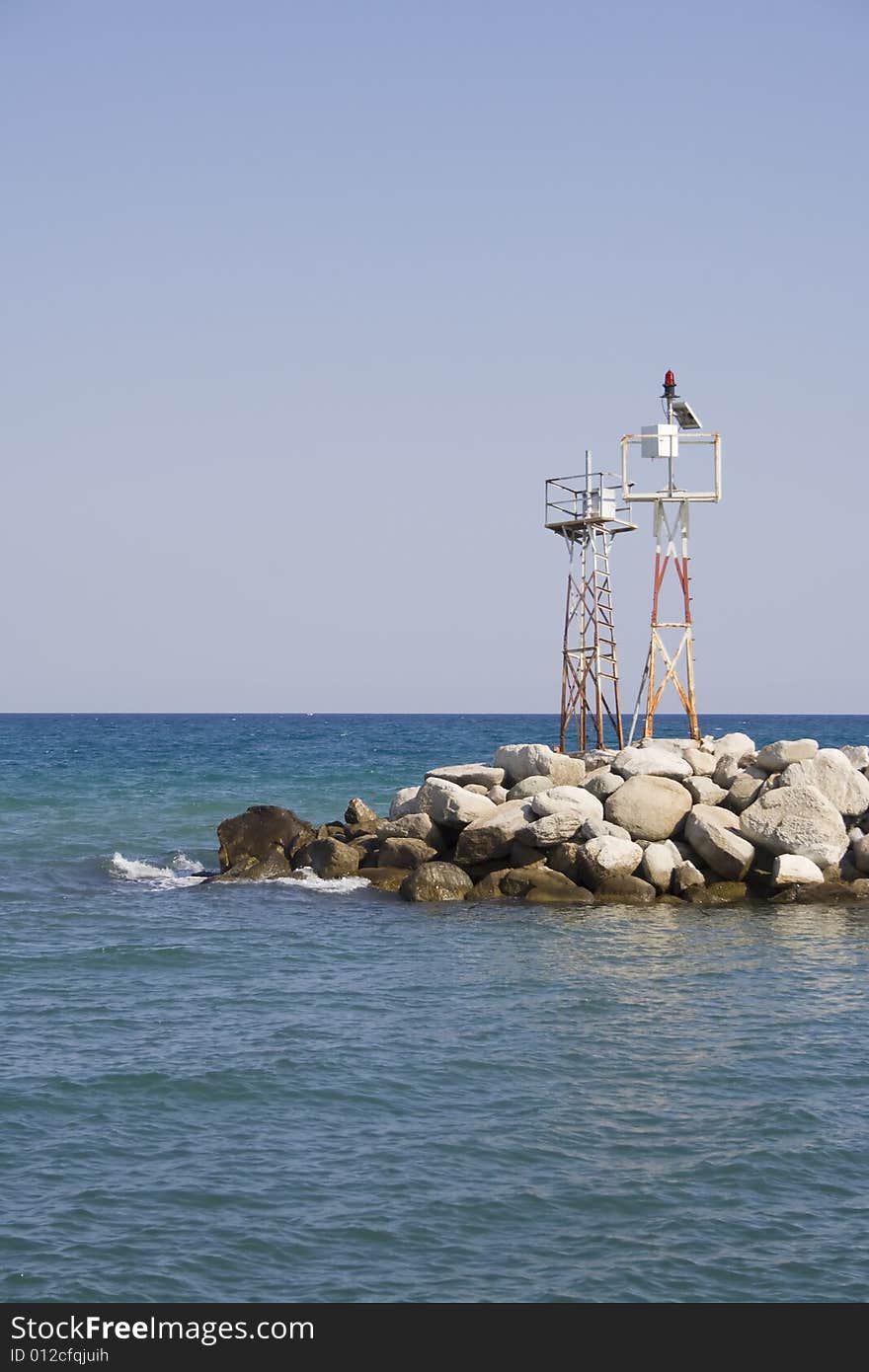 Boulder stones at the entrance to the port with watch-tower in the back