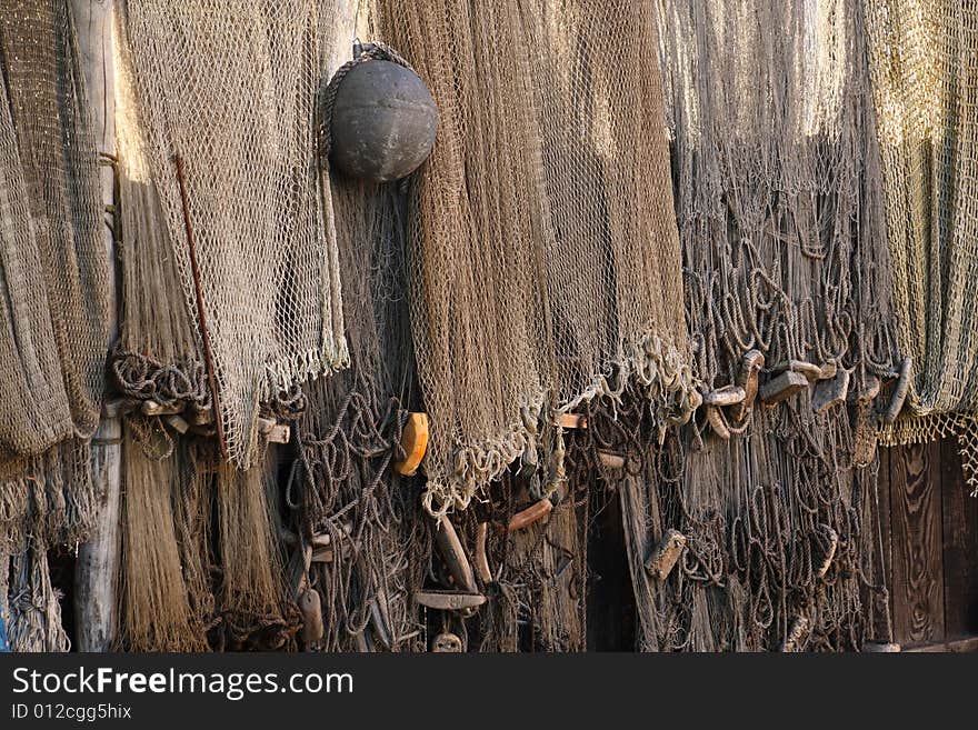 Fishing nets with floats drying on a hedge. Fishing nets with floats drying on a hedge