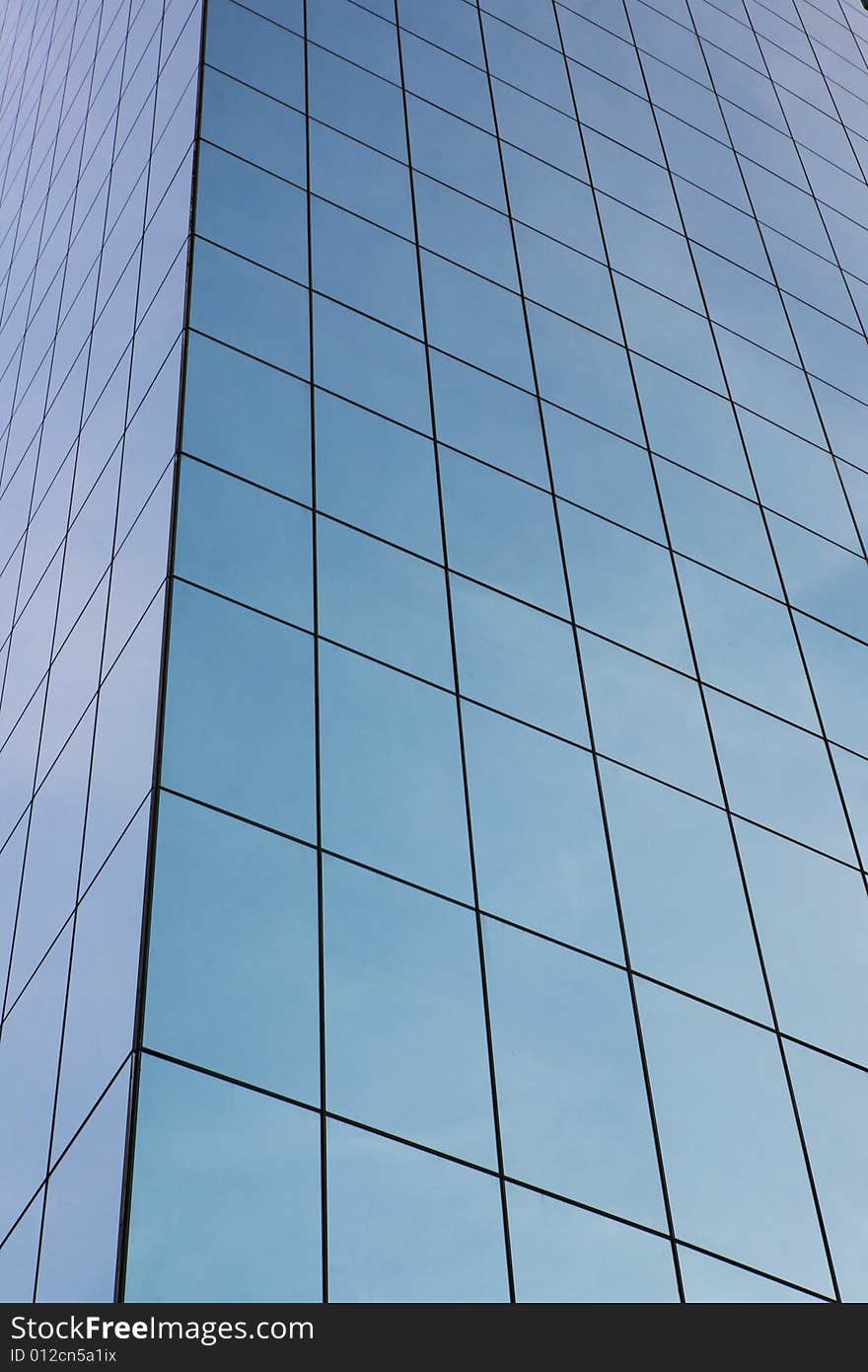 Glass wall of business center and sky reflection