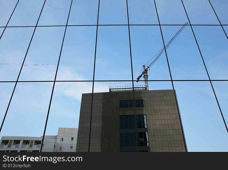 Glass wall of business center and sky reflection