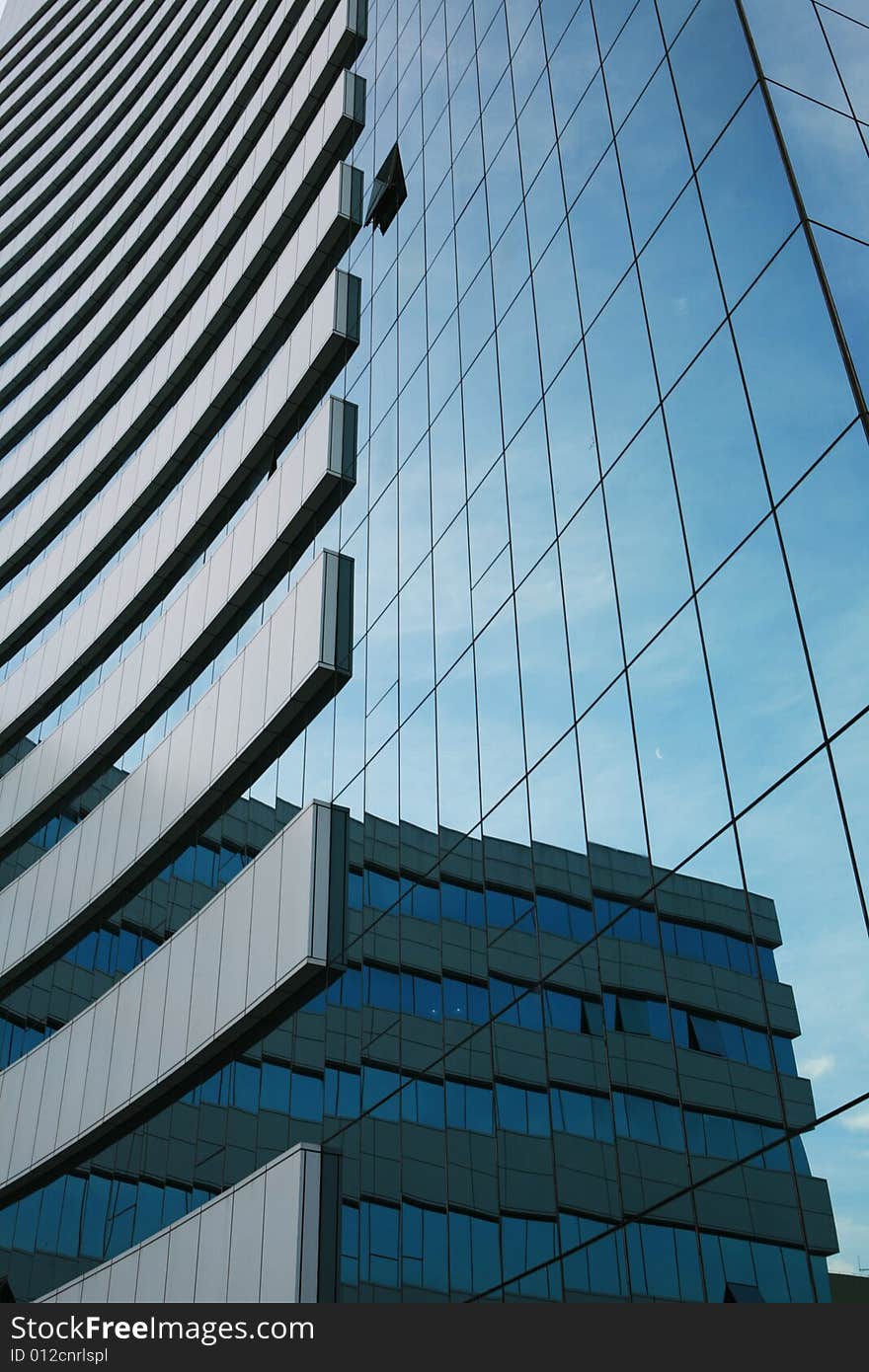 Glass wall of business center and sky reflection