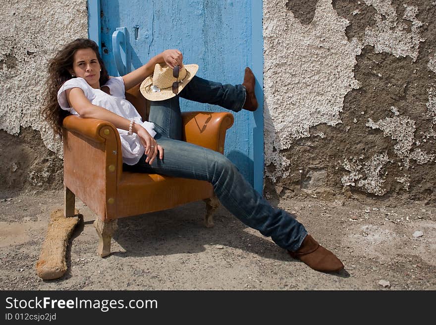 Young attractive woman posing on old house with blue door. Young attractive woman posing on old house with blue door