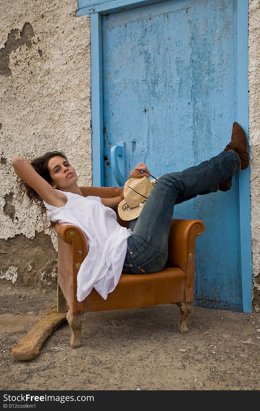 Young attractive woman posing on old house with blue door. Young attractive woman posing on old house with blue door