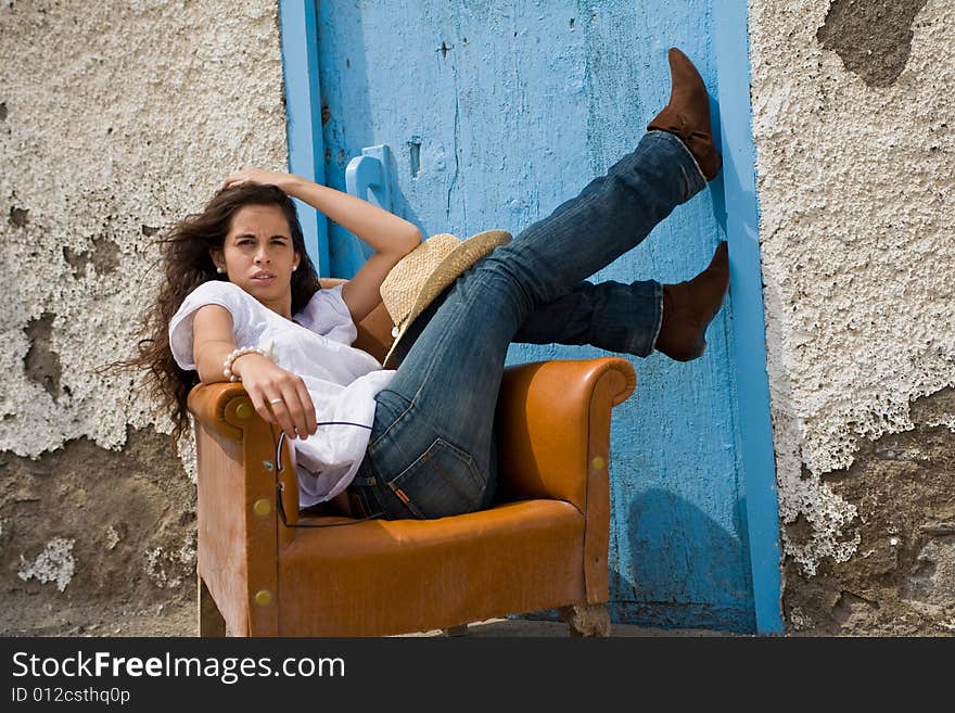 Young attractive woman posing on old house with blue door. Young attractive woman posing on old house with blue door