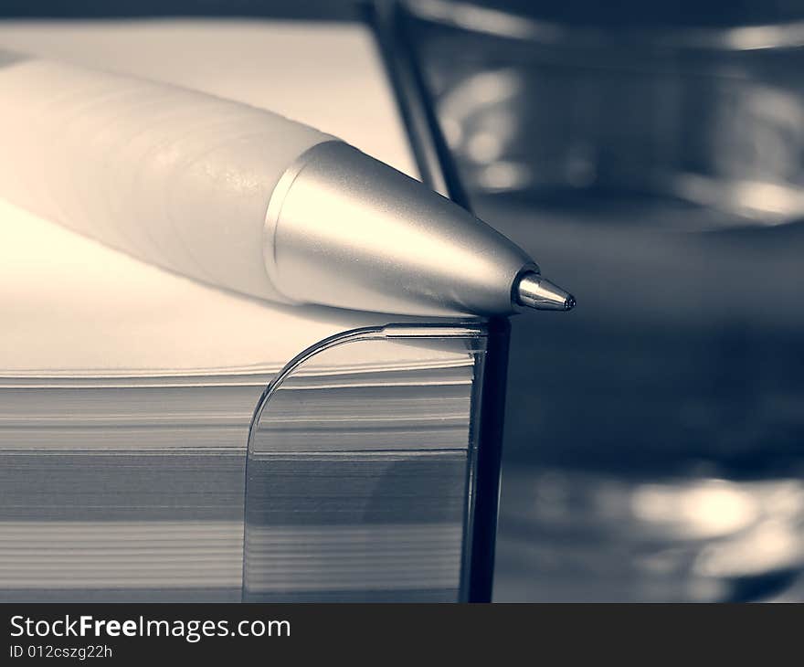 Pen, stack of note pads and glass of water (black and white). Pen, stack of note pads and glass of water (black and white)