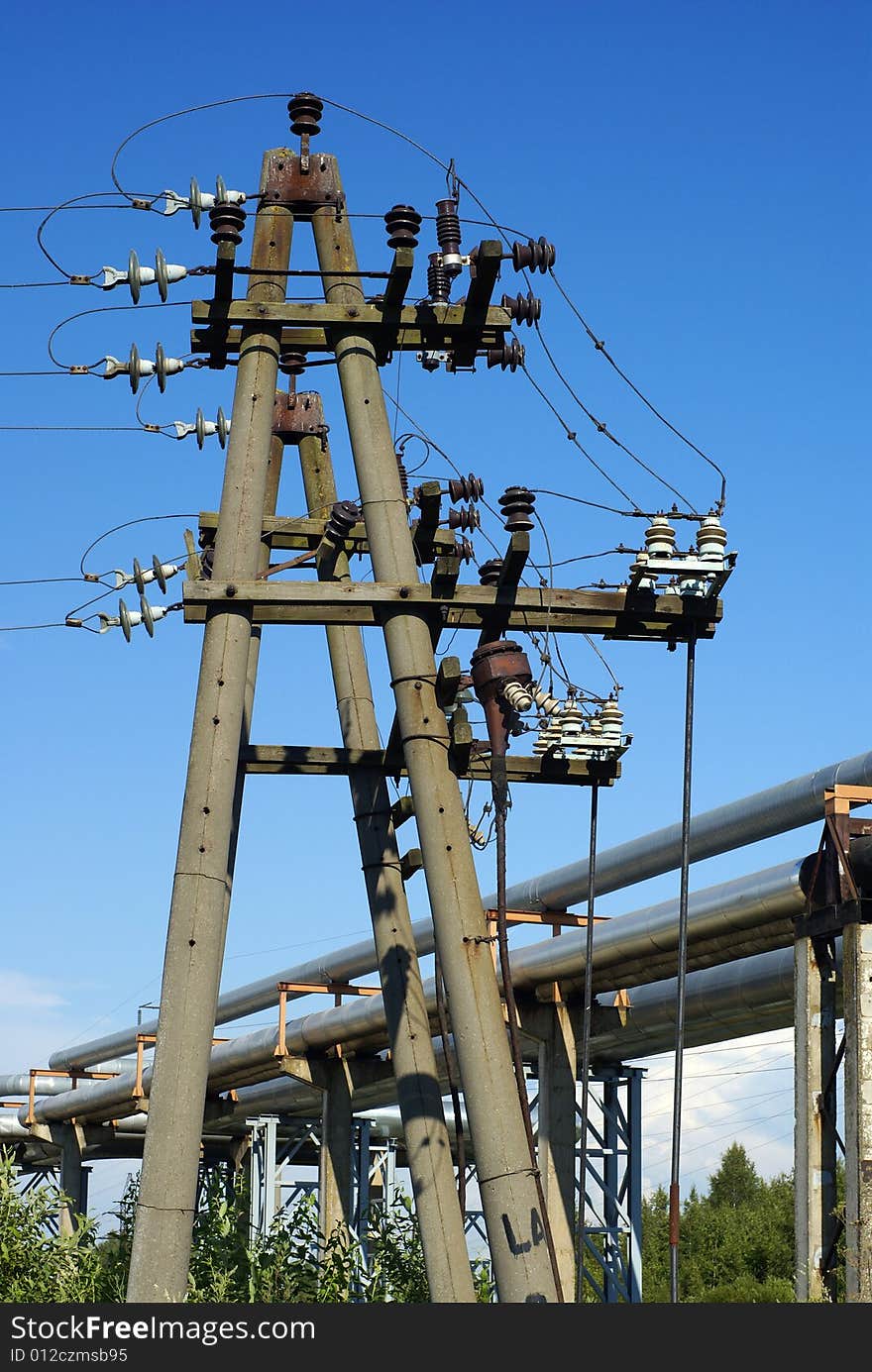 Industrial pipelines on pipe-bridge and electric power lines  against blue sky. Industrial pipelines on pipe-bridge and electric power lines  against blue sky