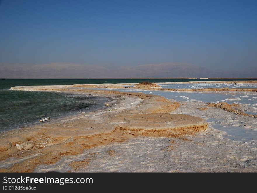 Salt on dead sea in the rays of sunset by evening