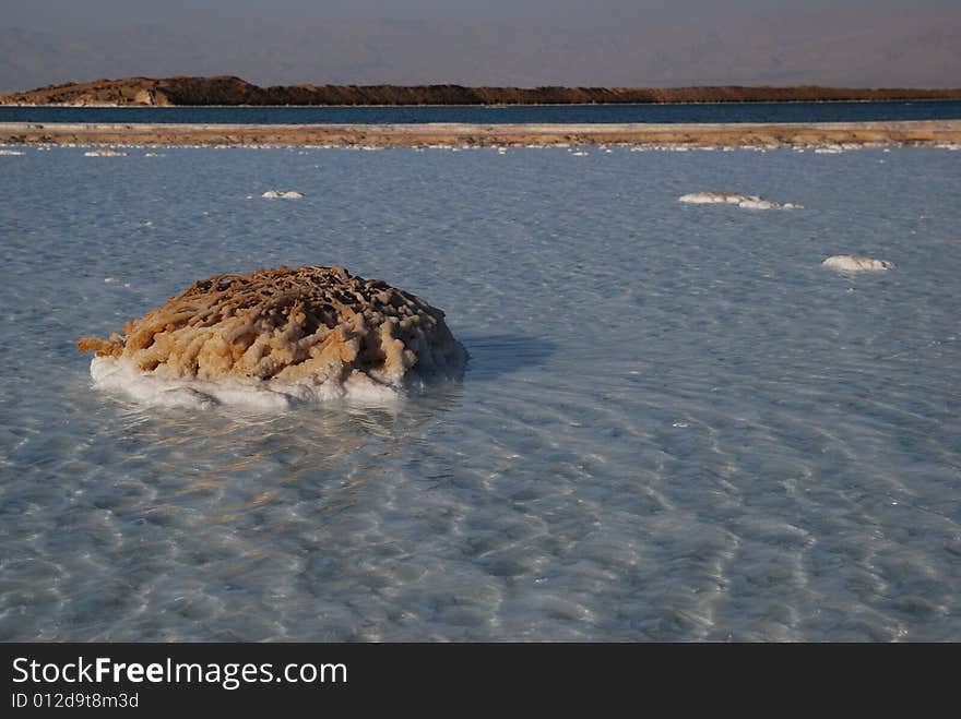 Salt on dead sea in the rays of sunset by evening