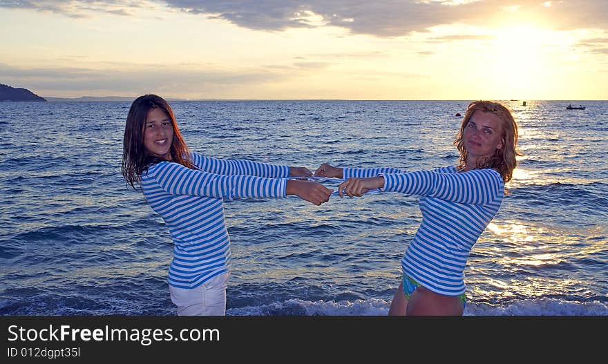 Mother and daughter on the beach during sunset