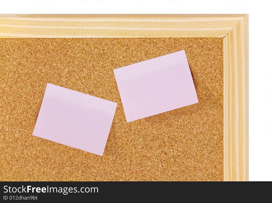 Pink sticky notes on brown corkboard with wooden frame