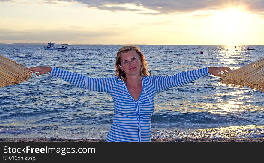 Woman stands between sunshades during sunset. Woman stands between sunshades during sunset