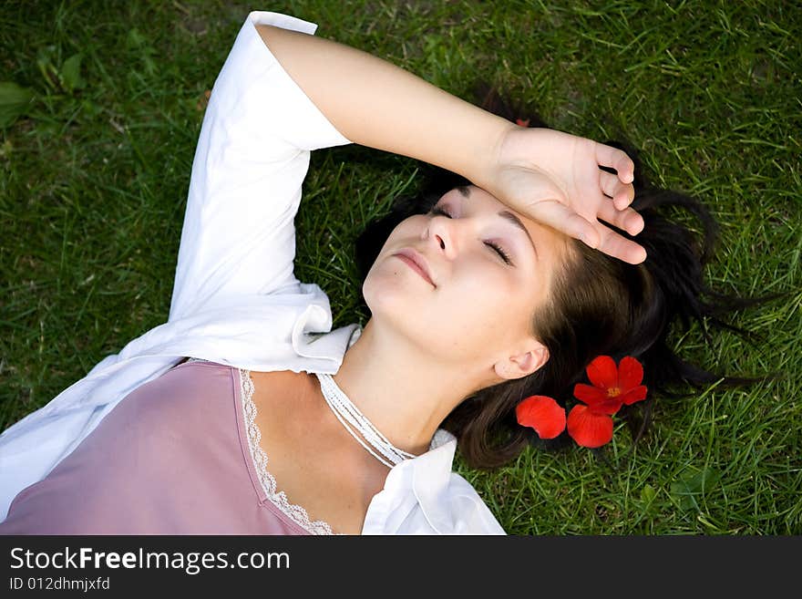 Attractive brunette woman lying on grass. Attractive brunette woman lying on grass