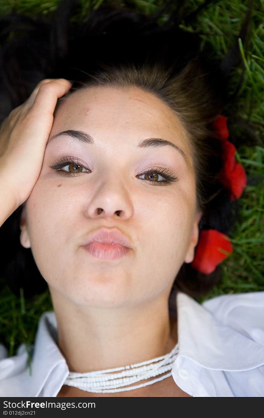 Attractive brunette woman relaxing on grass. Attractive brunette woman relaxing on grass