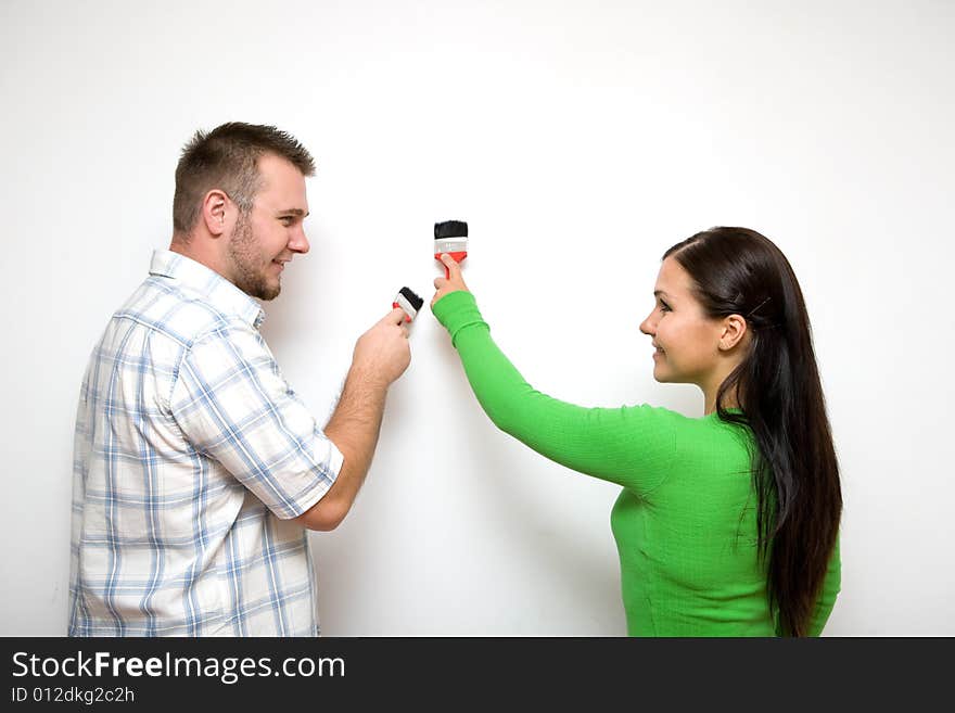 Happy casual couple painting wall. Happy casual couple painting wall