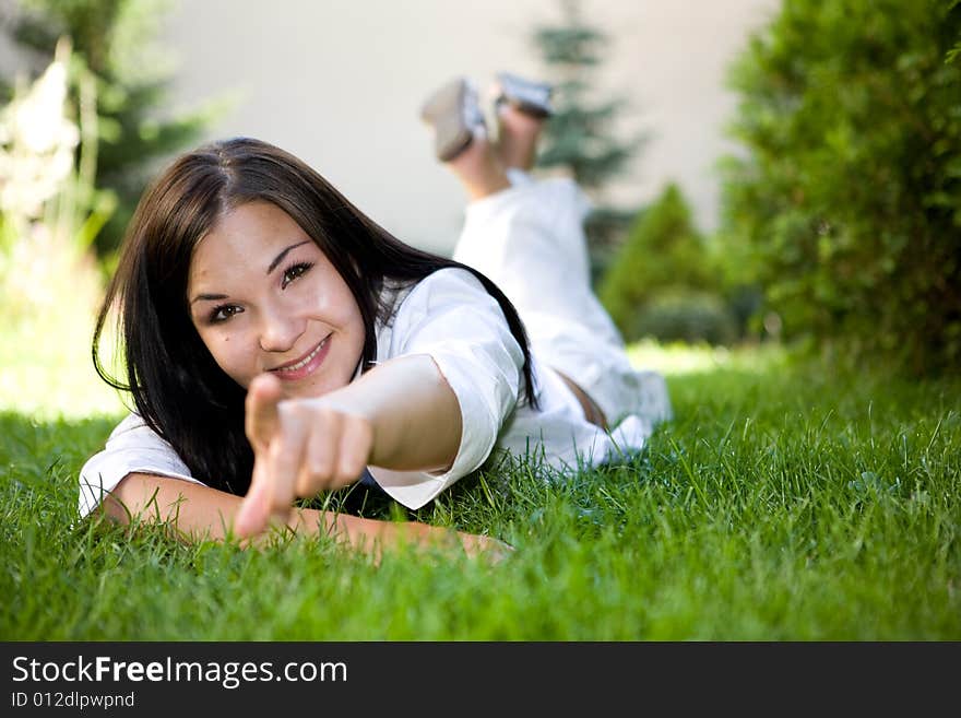 Attractive brunette woman lying on grass. Attractive brunette woman lying on grass