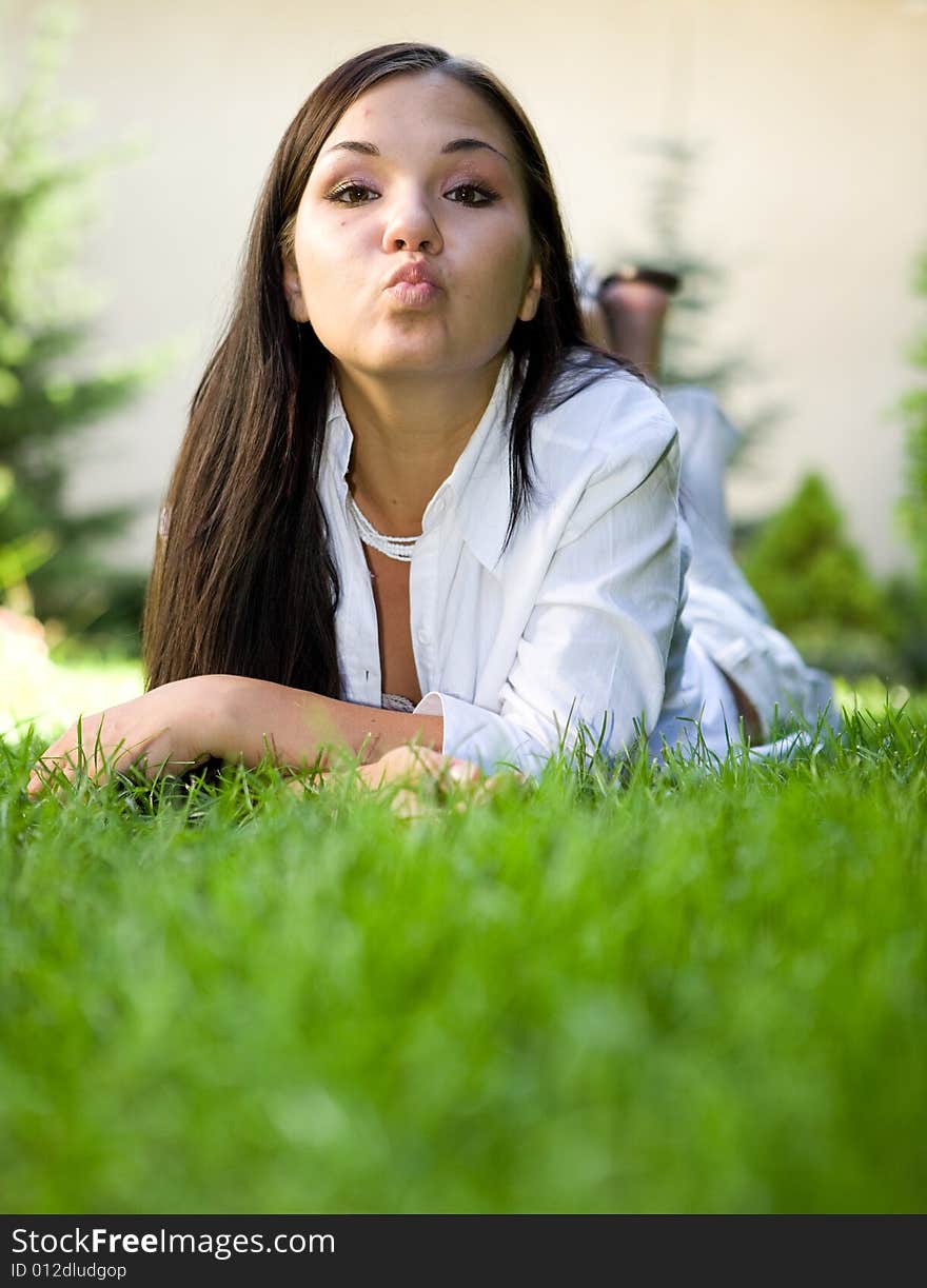 Attractive brunette woman lying on grass. Attractive brunette woman lying on grass