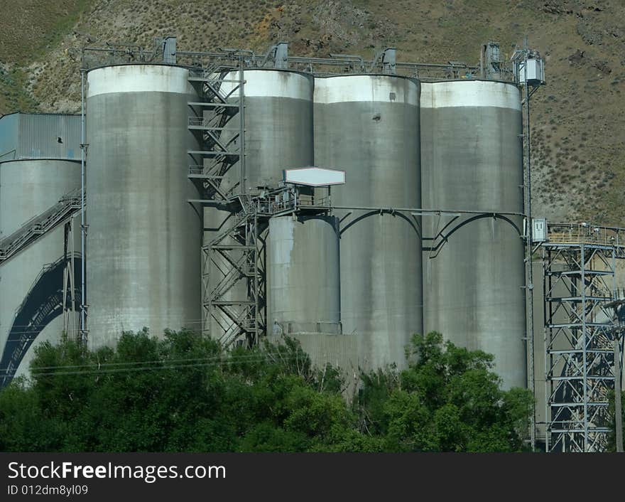 Concrete Factory with Copy Space Sign is an industrial factory with four tall silos.